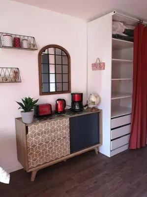 a room with a counter with a shelf and a mirror at Appartement rénové avec parking plein centre in Samoëns