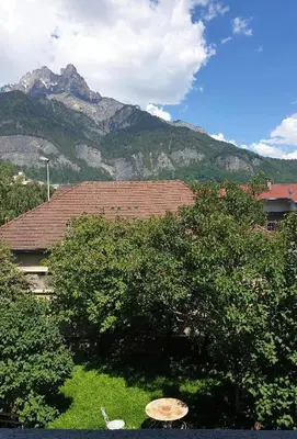 a house with a tree and a mountain in the background at Appartement au pays du Mont-Blanc in Sallanches