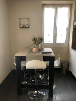 a dining room table with a white chair at it at Appartement au pays du Mont-Blanc in Sallanches