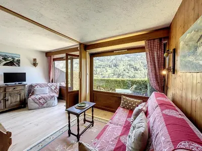 a living room with a couch and a large window at Studio Cabine pour 4 Pers à Deux Pas du Domaine Evasion Megève - FR-1-560-104 in Demi-Quartier