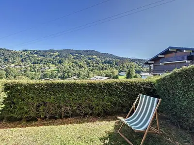 a blue and white chair sitting in front of a hedge at Studio Cabine pour 4 Pers à Deux Pas du Domaine Evasion Megève - FR-1-560-104 in Demi-Quartier