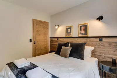 a bedroom with a large bed with a wooden headboard at White Pearl A02 - Alpes Travel - Chamonix - Sleeps 4 in Chamonix-Mont-Blanc