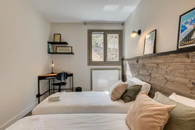 a bedroom with two beds and a wooden headboard at White Pearl A02 - Alpes Travel - Chamonix - Sleeps 4 in Chamonix-Mont-Blanc