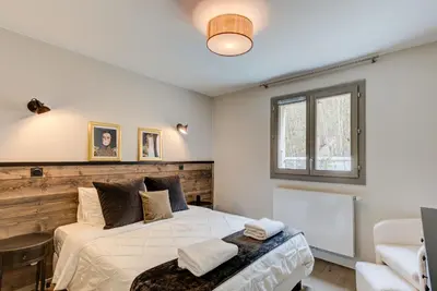 a bedroom with a large bed and a window at White Pearl A02 - Alpes Travel - Chamonix - Sleeps 4 in Chamonix-Mont-Blanc