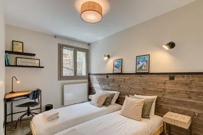 a bedroom with two beds and a desk in it at White Pearl A02 - Alpes Travel - Chamonix - Sleeps 4 in Chamonix-Mont-Blanc