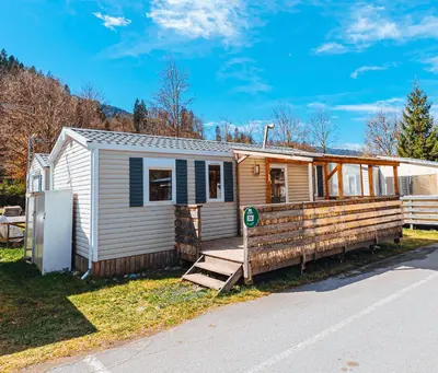 a tiny house with a porch and a fence at Bungalow 3 chambres pour 6 pers avec Climatisation Camping 3 etoiles in Samoëns