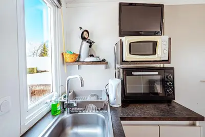 a kitchen with a sink and a microwave at Bungalow 3 chambres pour 6 pers avec Climatisation Camping 3 etoiles in Samoëns