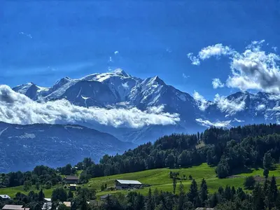 a mountain range with a green field and trees at Chalet neuf La Perle du Perron in Cordon