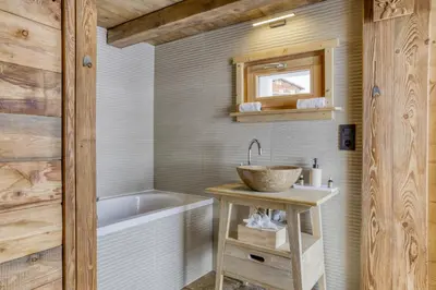 a bathroom with a sink and a bath tub at Chalet neuf La Perle du Perron in Cordon