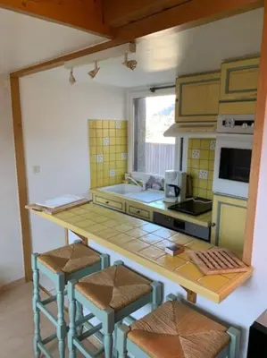 a kitchen with a counter and stools in a room at Duplex St Gervais rooftop - 500m des télécabines in Saint-Gervais-les-Bains