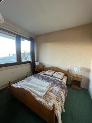 a bedroom with a large wooden bed with two lamps at Duplex St Gervais rooftop - 500m des télécabines in Saint-Gervais-les-Bains