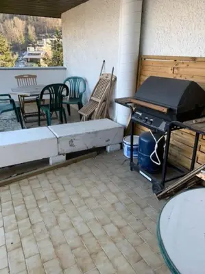 a outdoor patio with a grill and a table and chairs at Duplex St Gervais rooftop - 500m des télécabines in Saint-Gervais-les-Bains