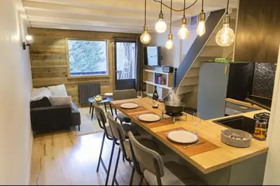 a kitchen and living room with a table and chairs at Bright apt facing the Mont Blanc chain in Les Houches