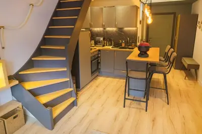 a kitchen with a staircase and a table in a room at Bright apt facing the Mont Blanc chain in Les Houches