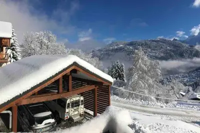 a hot tub on a snow covered hill with a house at L'ivresse du Mont-Blanc in Saint-Gervais-les-Bains
