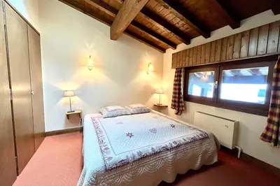 a bedroom with a bed in a room with a window at Évasion au Sommet in Combloux