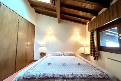 a bedroom with a bed in a room with a window at Évasion au Sommet in Combloux